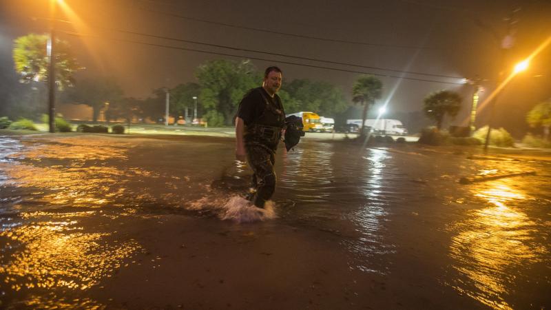 Person walking in flooding caused by tropical depression Nate