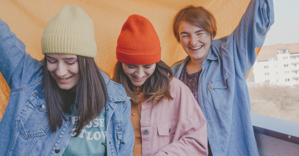 recurring giving: three women under a flag laughing